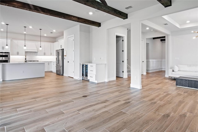 13323 Panama Beach Ct, Orlando, FL 32827 - unfurnished living room with wine cooler, recessed lighting, beamed ceiling, light wood-style floors, and a wainscoted wall
