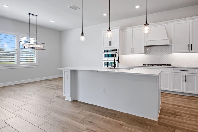 13323 Panama Beach Ct, Orlando, FL 32827 - kitchen with custom range hood, a sink, decorative backsplash, black cooktop, and light wood finished floors