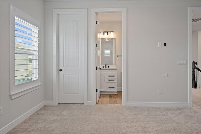 13323 Panama Beach Ct, Orlando, FL 32827 - unfurnished bedroom featuring light carpet, baseboards, a sink, and connected bathroom