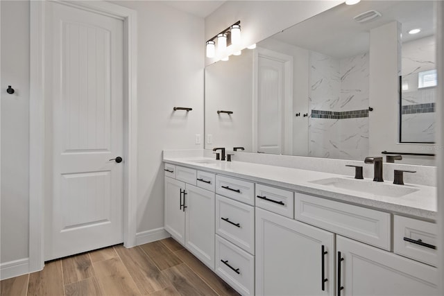 13323 Panama Beach Ct, Orlando, FL 32827 - full bathroom with double vanity, a marble finish shower, wood finished floors, baseboards, and recessed lighting
