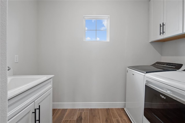 13323 Panama Beach Ct, Orlando, FL 32827 - laundry room featuring washer and dryer, cabinet space, wood finished floors, and baseboards