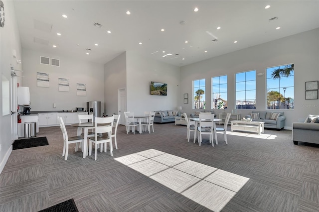 13323 Panama Beach Ct, Orlando, FL 32827 - dining area with light carpet, a high ceiling, recessed lighting, and baseboards