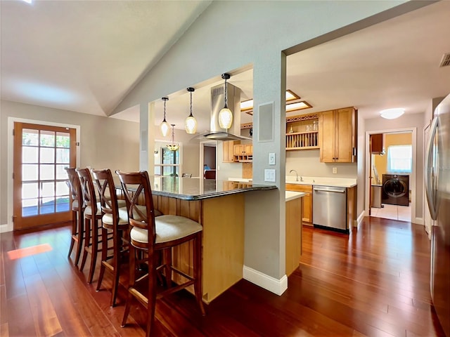 5724 Pitch Pine Dr, Orlando, FL 32819 - kitchen featuring stainless steel appliances, washer / clothes dryer, island range hood, lofted ceiling, and dark wood finished floors