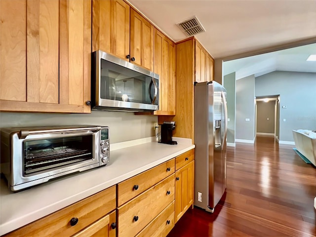 5724 Pitch Pine Dr, Orlando, FL 32819 - kitchen featuring stainless steel appliances, light countertops, dark wood-type flooring, brown cabinetry, and vaulted ceiling