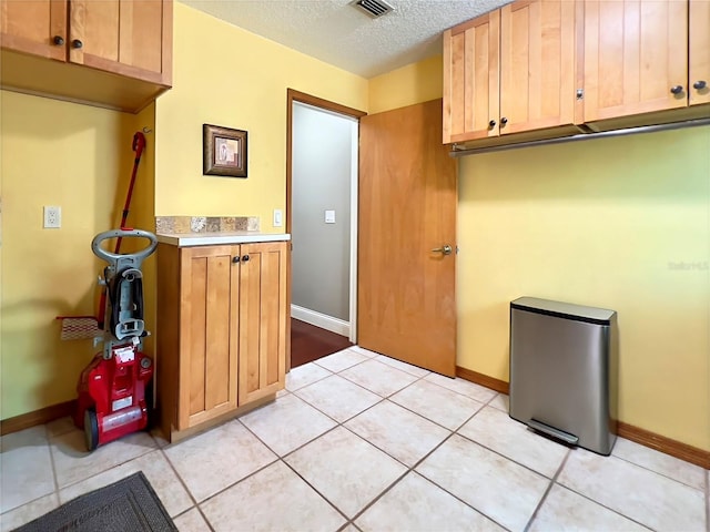 5724 Pitch Pine Dr, Orlando, FL 32819 - laundry room featuring a textured ceiling and light tile patterned floors