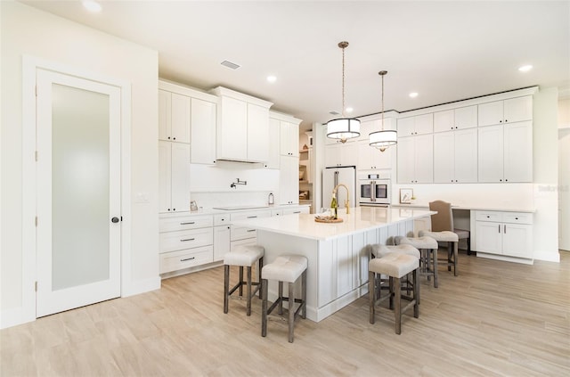 508 Topsail Dr, Rockledge, FL 32955 - kitchen with light wood-style flooring, a breakfast bar, light countertops, and recessed lighting