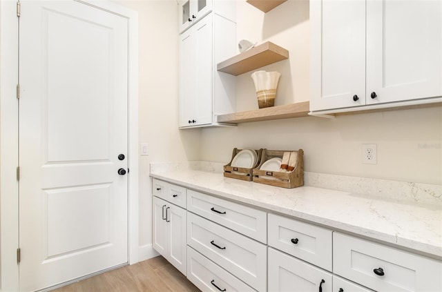 508 Topsail Dr, Rockledge, FL 32955 - kitchen featuring open shelves, white cabinets, light wood-style flooring, and light stone counters