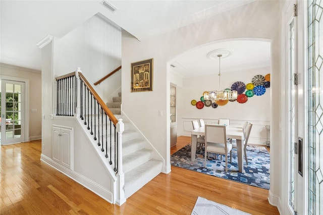 1420 Palmer Ave, Winter Park, FL 32789 - foyer entrance with arched walkways, wood finished floors, ornamental molding, stairs, and a chandelier