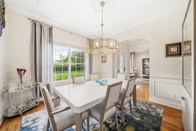 1420 Palmer Ave, Winter Park, FL 32789 - dining area with arched walkways, a chandelier, wood finished floors, wainscoting, and a decorative wall