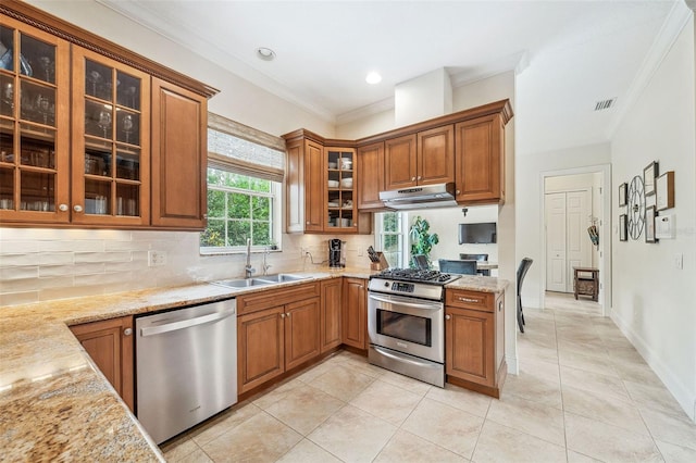 1420 Palmer Ave, Winter Park, FL 32789 - kitchen featuring stainless steel appliances, a sink, brown cabinets, ornamental molding, and decorative backsplash