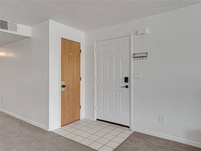 2729 N Poinciana Blvd Unit 125, Kissimmee, FL 34746 - entryway featuring a textured ceiling, light carpet, baseboards, and light tile patterned flooring