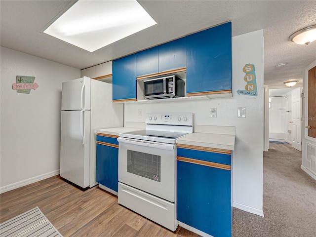 2729 N Poinciana Blvd Unit 125, Kissimmee, FL 34746 - kitchen with white appliances, blue cabinets, light countertops, baseboards, and a textured ceiling