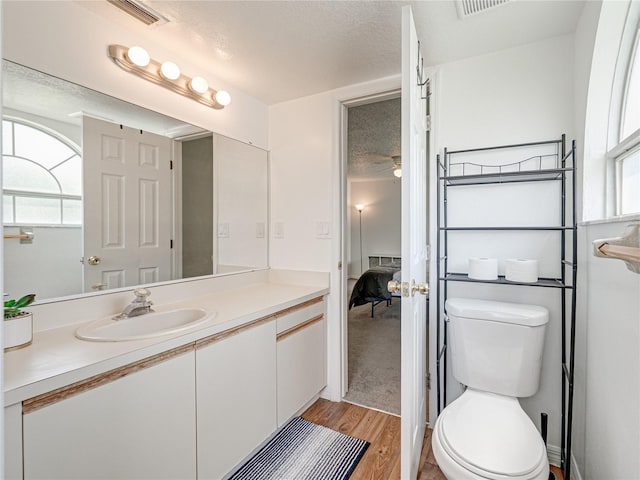 2729 N Poinciana Blvd Unit 125, Kissimmee, FL 34746 - bathroom with vanity, wood finished floors, toilet, a textured ceiling, and ceiling fan