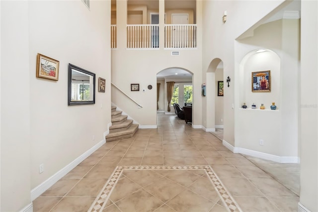 1429 Arbitus Cir, Oviedo, FL 32765 - entrance foyer featuring arched walkways, stairs, a towering ceiling, baseboards, and light tile patterned floors