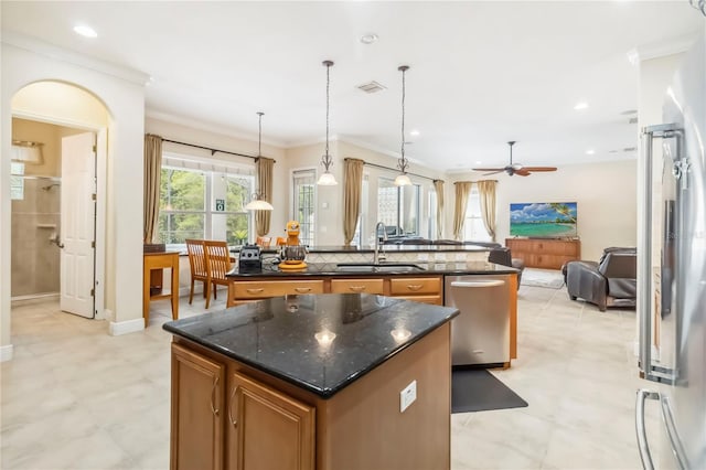 1429 Arbitus Cir, Oviedo, FL 32765 - kitchen with an island with sink, a sink, brown cabinetry, ornamental molding, and open floor plan