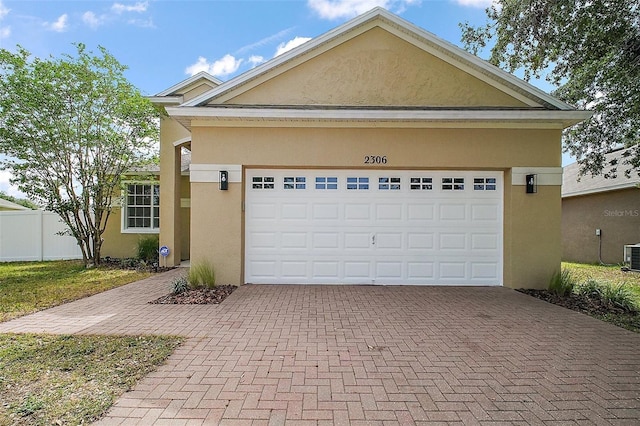 2306 Valhalla Dr, Tavares, FL 32778 - view of front facade with stucco siding, decorative driveway, an attached garage, and cooling unit