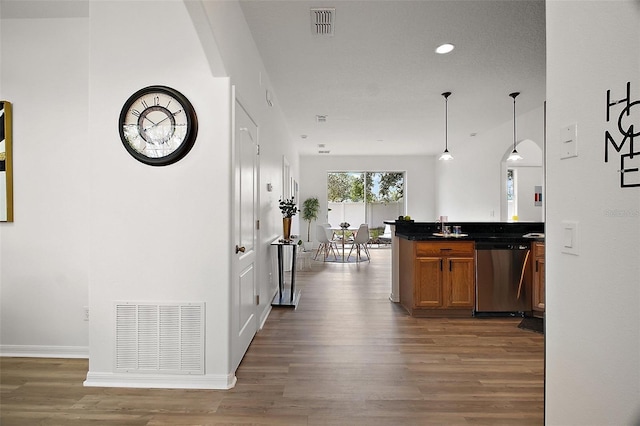 2306 Valhalla Dr, Tavares, FL 32778 - kitchen featuring dishwasher, wood finished floors, brown cabinetry, dark countertops, and pendant lighting