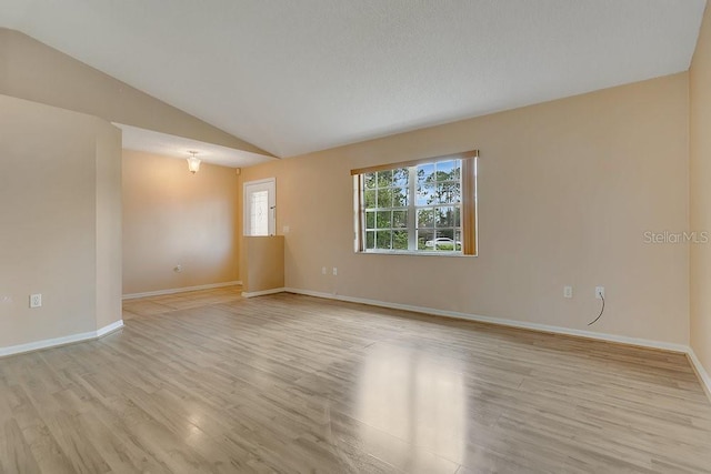 2772 Pelham Cir, Deltona, FL 32738 - empty room with light wood-style floors, vaulted ceiling, and baseboards