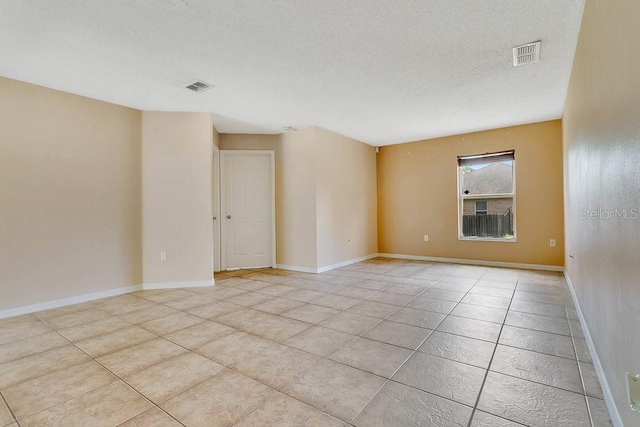 2772 Pelham Cir, Deltona, FL 32738 - empty room featuring a textured ceiling, light tile patterned floors, and baseboards