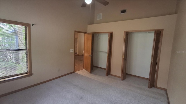 900 Red Fox Rd, Altamonte Springs, FL 32714 - unfurnished bedroom with two closets, light carpet, multiple windows, baseboards, and a high ceiling