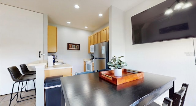 2411 Caravelle Cir, Kissimmee, FL 34746 - kitchen with white appliances, a sink, a peninsula, a breakfast bar, and recessed lighting