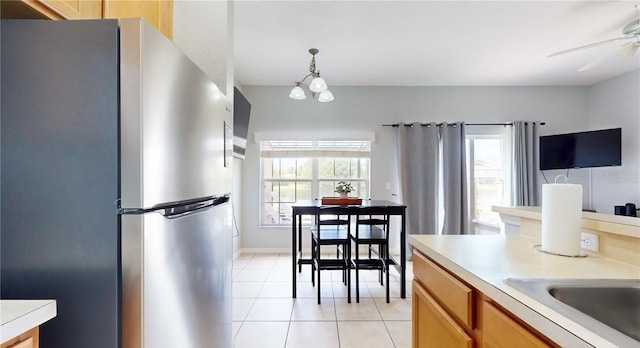 2411 Caravelle Cir, Kissimmee, FL 34746 - kitchen featuring freestanding refrigerator, light tile patterned flooring, light countertops, a ceiling fan, and pendant lighting