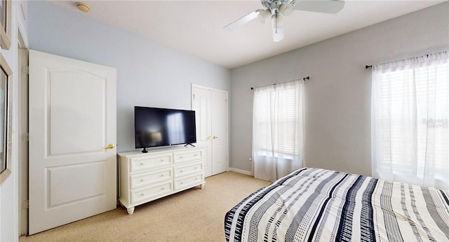 2411 Caravelle Cir, Kissimmee, FL 34746 - bedroom with multiple windows, light carpet, baseboards, and ceiling fan