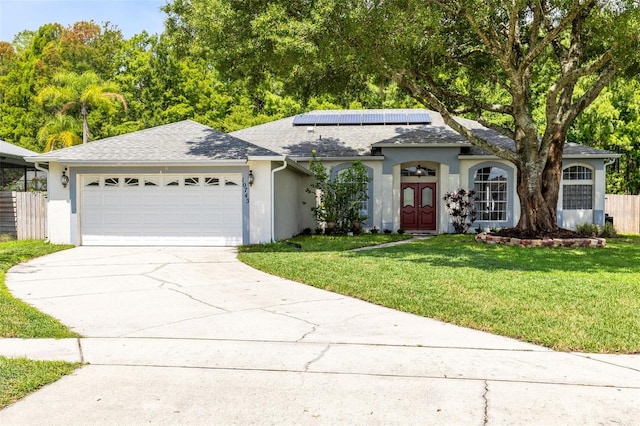 10743 Fairhaven Way, Orlando, FL 32825 - ranch-style home featuring driveway, a garage, stucco siding, a front lawn, and roof mounted solar panels