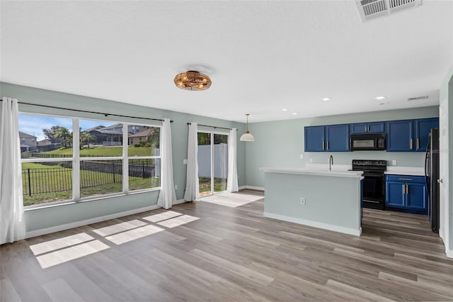 126 San Carlo Rd, Davenport, FL 33896 - kitchen with black appliances, blue cabinets, light countertops, wood finished floors, and baseboards