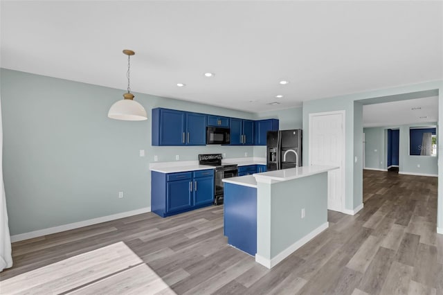 126 San Carlo Rd, Davenport, FL 33896 - kitchen featuring black appliances, blue cabinetry, light countertops, light wood finished floors, and recessed lighting
