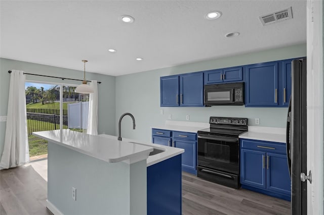 126 San Carlo Rd, Davenport, FL 33896 - kitchen with black appliances, blue cabinets, a sink, wood finished floors, and light countertops