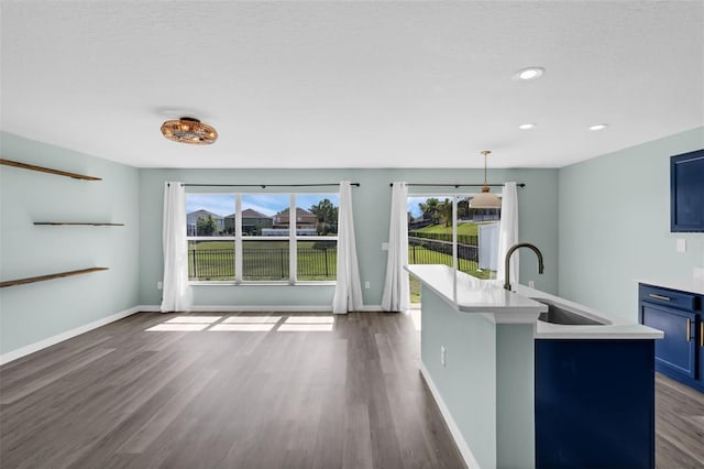 126 San Carlo Rd, Davenport, FL 33896 - kitchen featuring blue cabinets, a sink, dark wood finished floors, light countertops, and recessed lighting