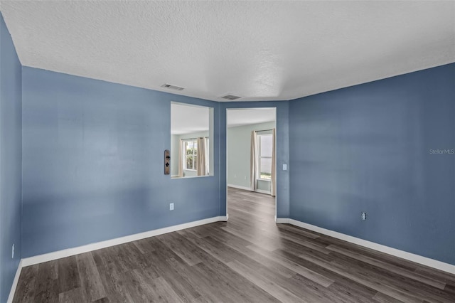 126 San Carlo Rd, Davenport, FL 33896 - empty room featuring dark wood-style floors, baseboards, and a textured ceiling