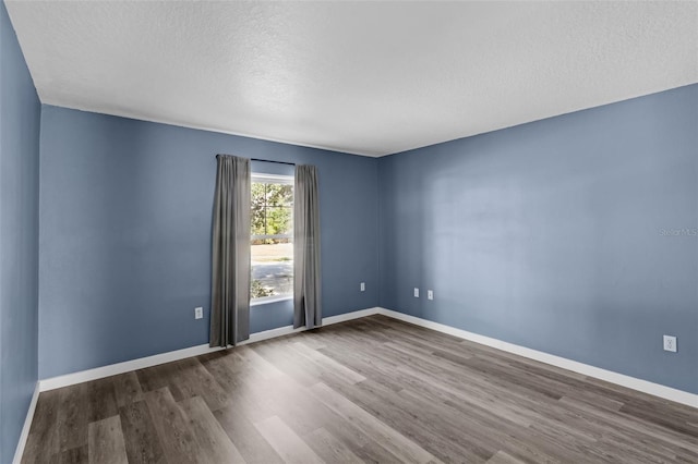 126 San Carlo Rd, Davenport, FL 33896 - empty room with wood finished floors, a textured ceiling, and baseboards