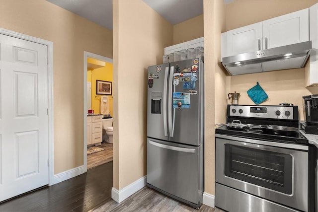 173 Villa Di Este Ter Unit 209, Lake Mary, FL 32746 - kitchen featuring appliances with stainless steel finishes, range hood, wood finished floors, white cabinets, and baseboards