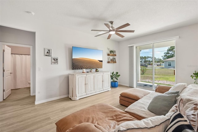 1909 Thomasville Ave SE, Palm Bay, FL 32909 - living room featuring ceiling fan, light wood-style floors, baseboards, and a textured ceiling