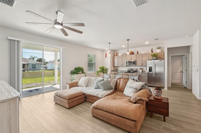 1909 Thomasville Ave SE, Palm Bay, FL 32909 - living room featuring ceiling fan, light wood-style floors, recessed lighting, and a textured ceiling