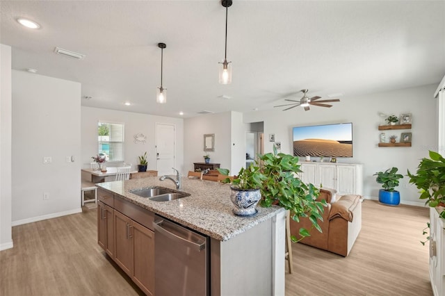1909 Thomasville Ave SE, Palm Bay, FL 32909 - kitchen featuring stainless steel dishwasher, a sink, light wood finished floors, open floor plan, and baseboards