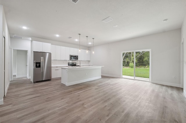 8944 N Pitcairn Way, Citrus Springs, FL 34434 - kitchen featuring stainless steel appliances, light wood-style flooring, open floor plan, baseboards, and white cabinetry