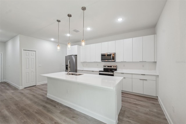 8944 N Pitcairn Way, Citrus Springs, FL 34434 - kitchen with stainless steel appliances, a sink, an island with sink, white cabinets, and light wood-style flooring