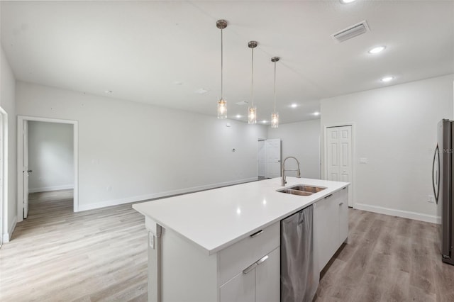 8944 N Pitcairn Way, Citrus Springs, FL 34434 - kitchen featuring a sink, appliances with stainless steel finishes, light wood-style floors, light countertops, and a center island with sink
