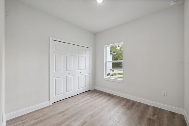 8944 N Pitcairn Way, Citrus Springs, FL 34434 - unfurnished bedroom featuring baseboards, light wood-style floors, and a closet