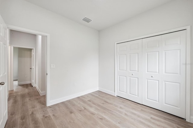 8944 N Pitcairn Way, Citrus Springs, FL 34434 - unfurnished bedroom with light wood-type flooring, baseboards, and a closet