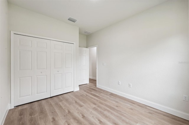 8944 N Pitcairn Way, Citrus Springs, FL 34434 - unfurnished bedroom with light wood-type flooring, a closet, and baseboards