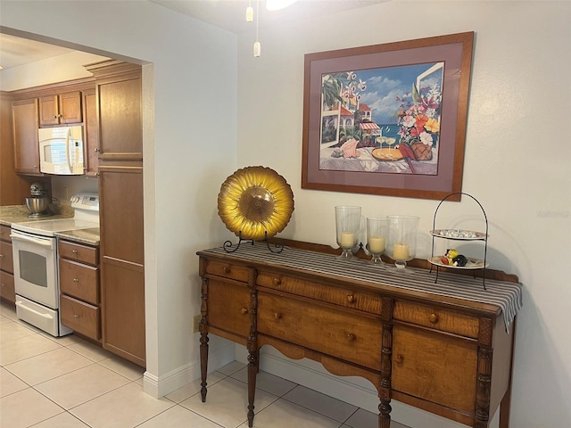 2426 Windward Way, Winter Park, FL 32792 - kitchen featuring white appliances, light tile patterned flooring, brown cabinets, and baseboards