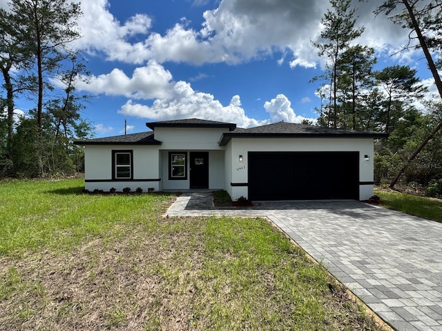16463 SW 55th Court Rd, Ocala, FL 34473 - prairie-style house with stucco siding, a garage, decorative driveway, and a front lawn
