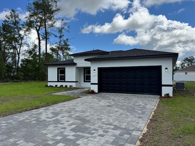 16463 SW 55th Court Rd, Ocala, FL 34473 - prairie-style home with stucco siding, decorative driveway, a front yard, an attached garage, and central AC unit