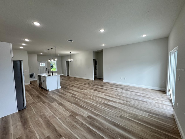 16463 SW 55th Court Rd, Ocala, FL 34473 - kitchen with a chandelier, freestanding refrigerator, recessed lighting, open floor plan, and wood finished floors