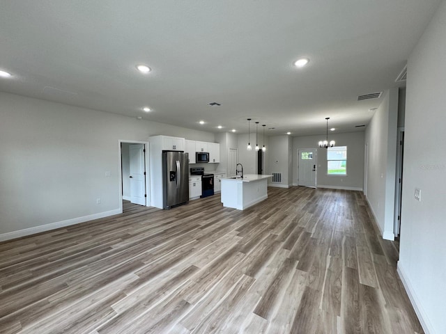16463 SW 55th Court Rd, Ocala, FL 34473 - unfurnished living room featuring a sink, wood finished floors, a chandelier, recessed lighting, and baseboards