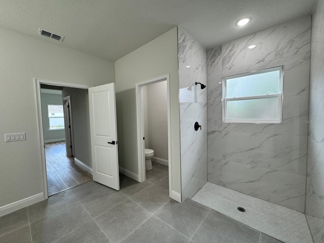 16463 SW 55th Court Rd, Ocala, FL 34473 - full bath featuring toilet, plenty of natural light, a marble finish shower, a textured ceiling, and baseboards